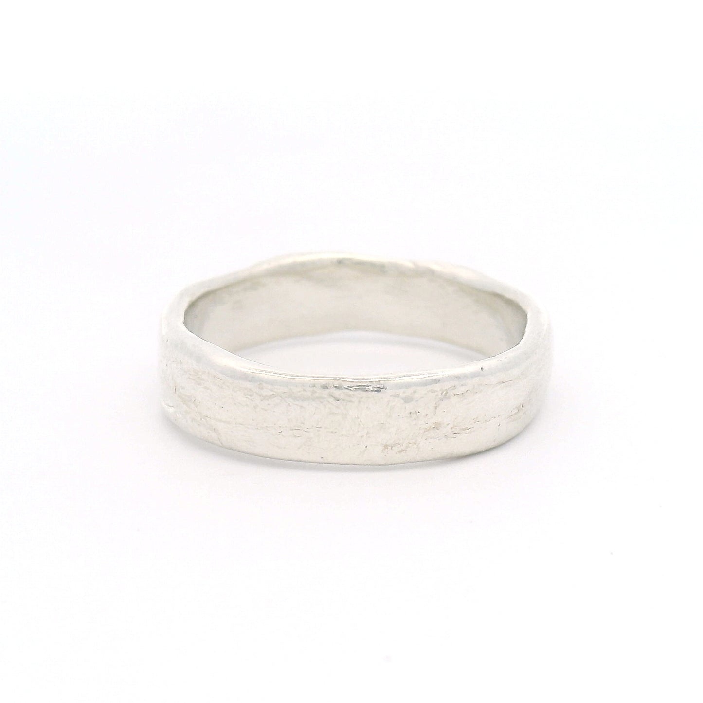 Sterling silver 5.5mm wedding band featuring a soft organic texture, gently domed profile, and comfort-fit interior.
