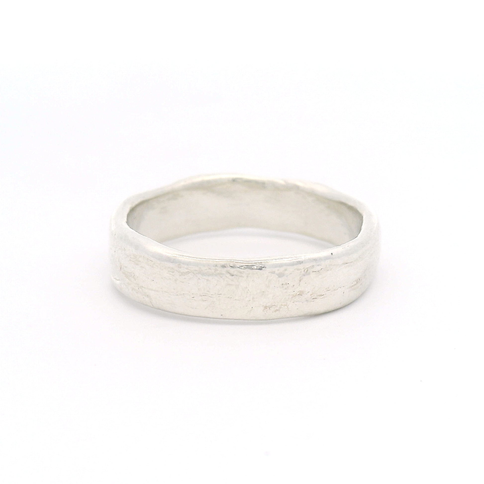 Sterling silver 5.5mm wedding band featuring a soft organic texture, gently domed profile, and comfort-fit interior.