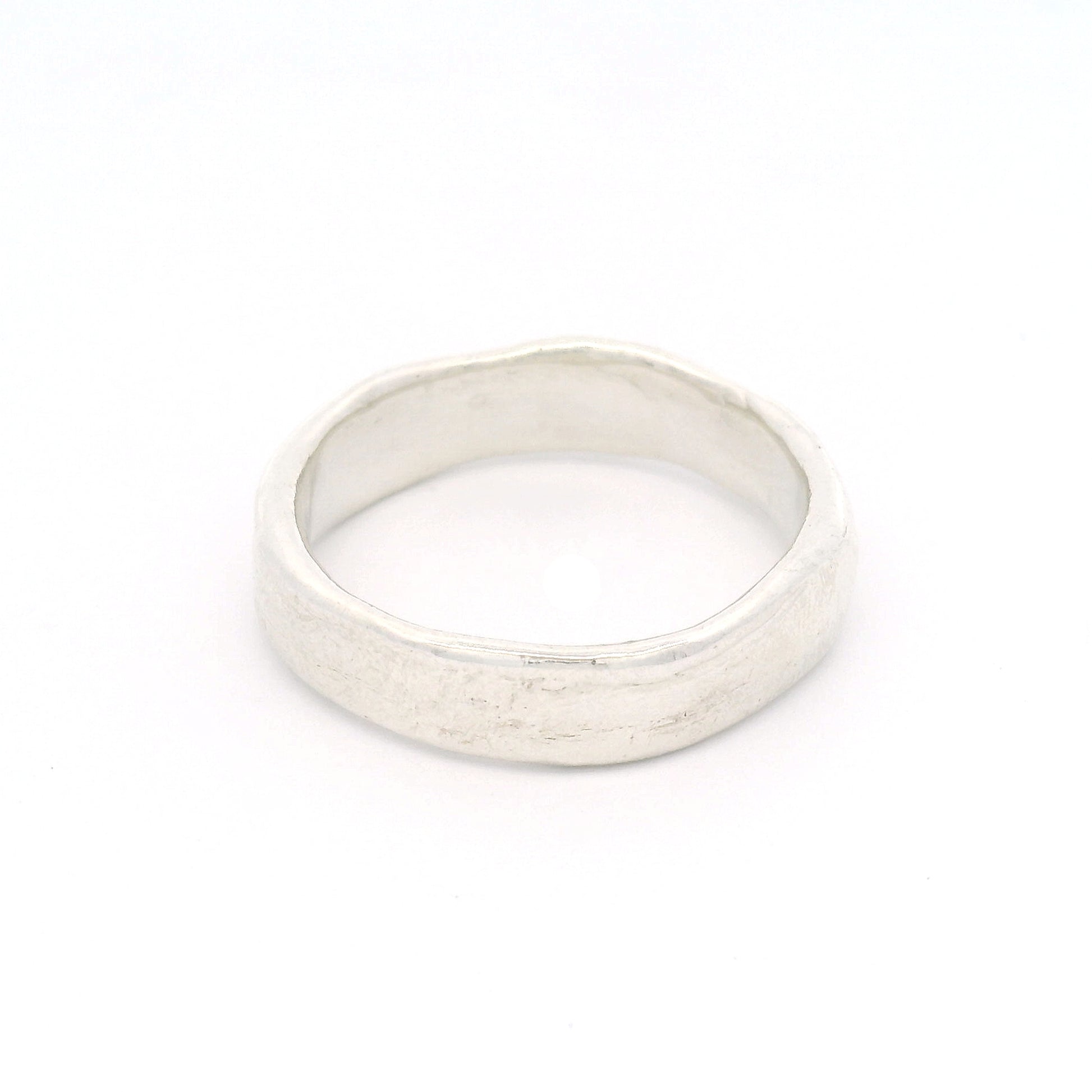 Sterling silver 5.5mm wedding band featuring a soft organic texture, gently domed profile, and comfort-fit interior.