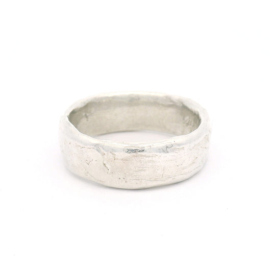 Sterling silver 7.5mm wedding band featuring a soft organic texture, gently domed profile, and comfort-fit interior.