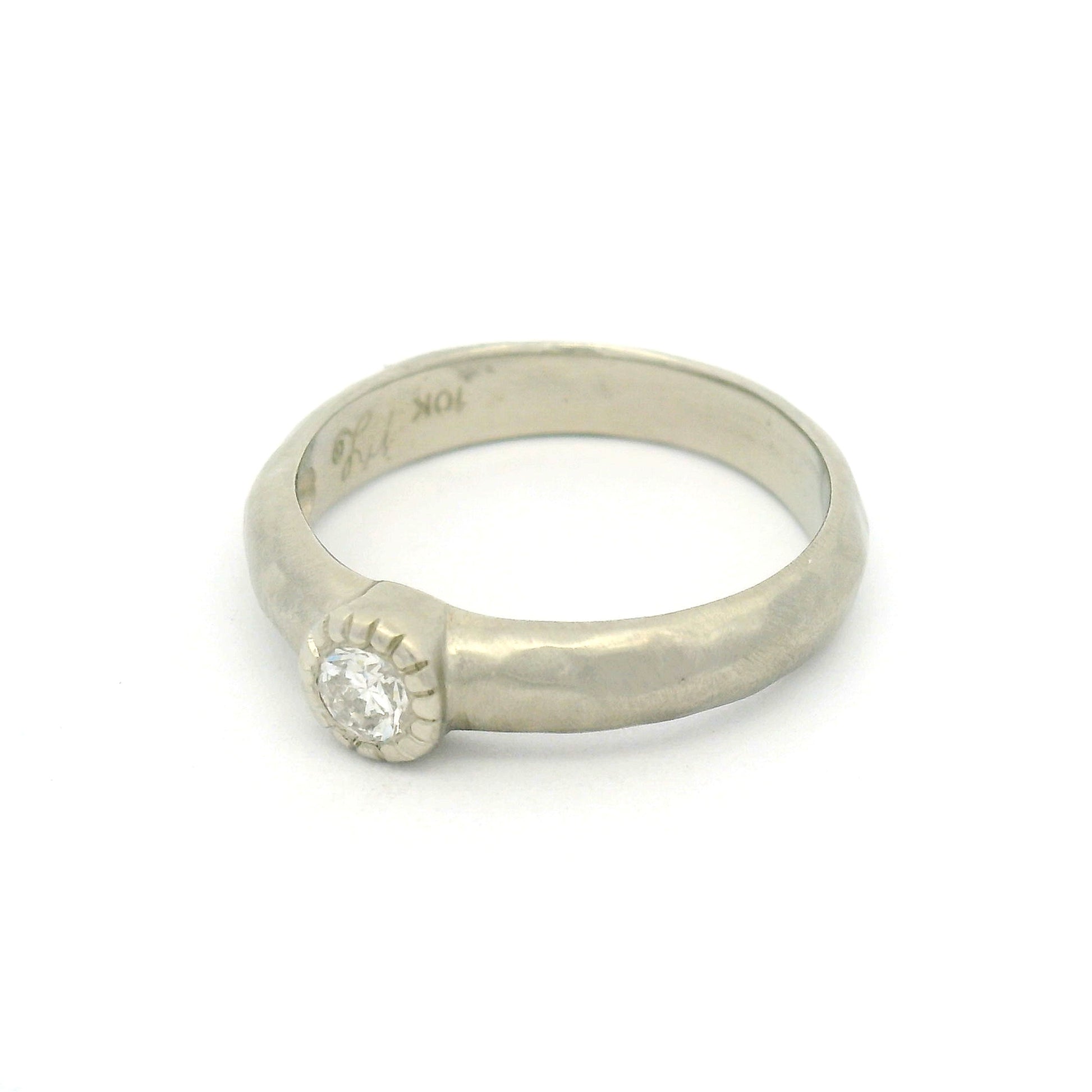 10K white gold organic sculpted solitaire ring with bezel-set 0.18ct round brilliant-cut diamond and milgrain-detailed bezel.