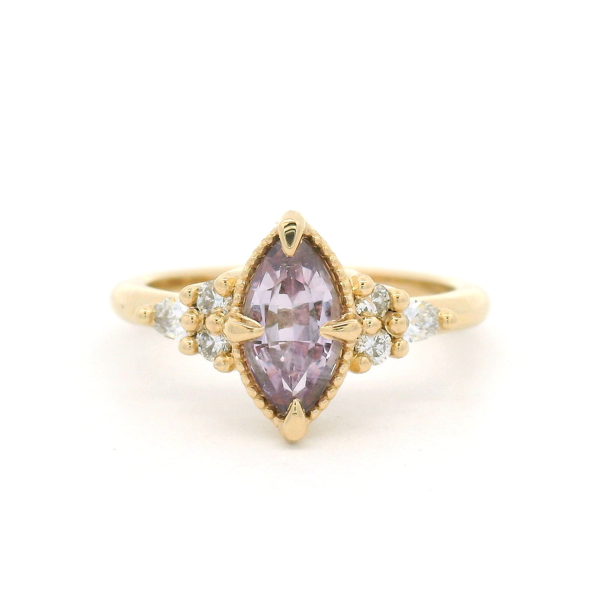 14K yellow gold engagement ring featuring a claw-set natural 1.20ct pink marquise sapphire with four round brilliant-cut and two pear-shaped lab-grown diamond accents totalling 0.19cts.