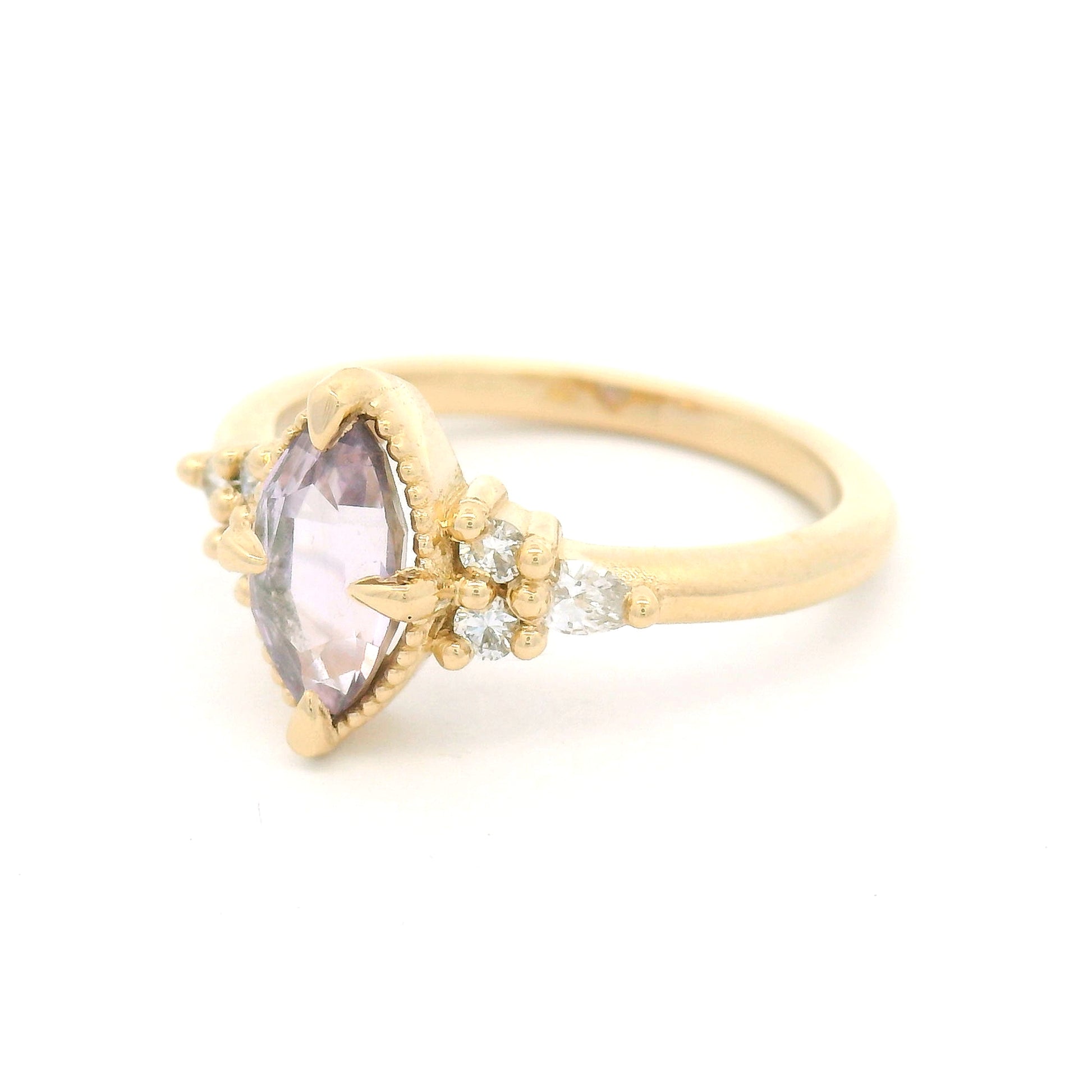 14K yellow gold engagement ring featuring a claw-set natural 1.20ct pink marquise sapphire with four round brilliant-cut and two pear-shaped lab-grown diamond accents totalling 0.19cts.