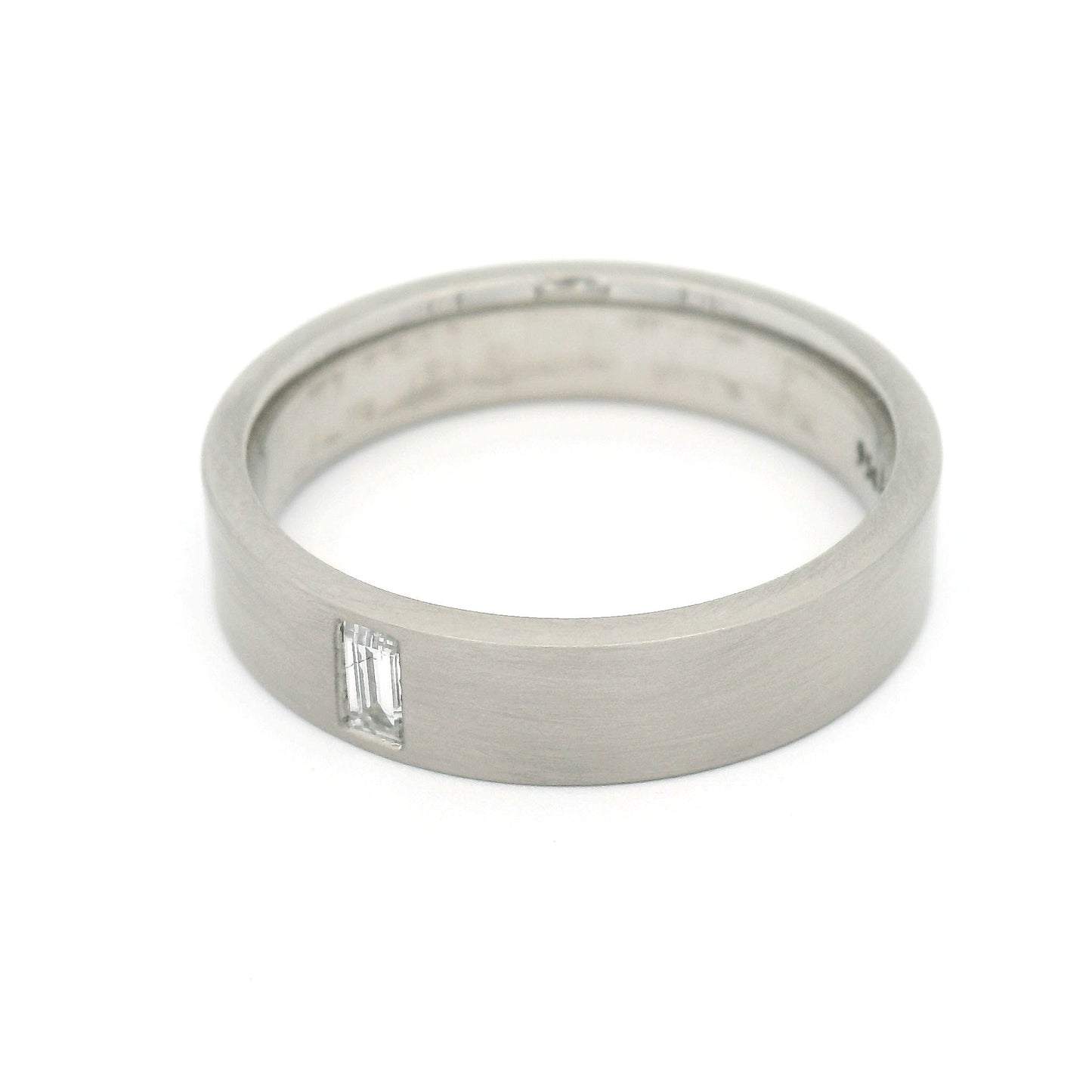 5mm 950 palladium comfort-fit band with a flat brushed finish and flush-set 0.12ct lab-grown baguette-cut diamond.