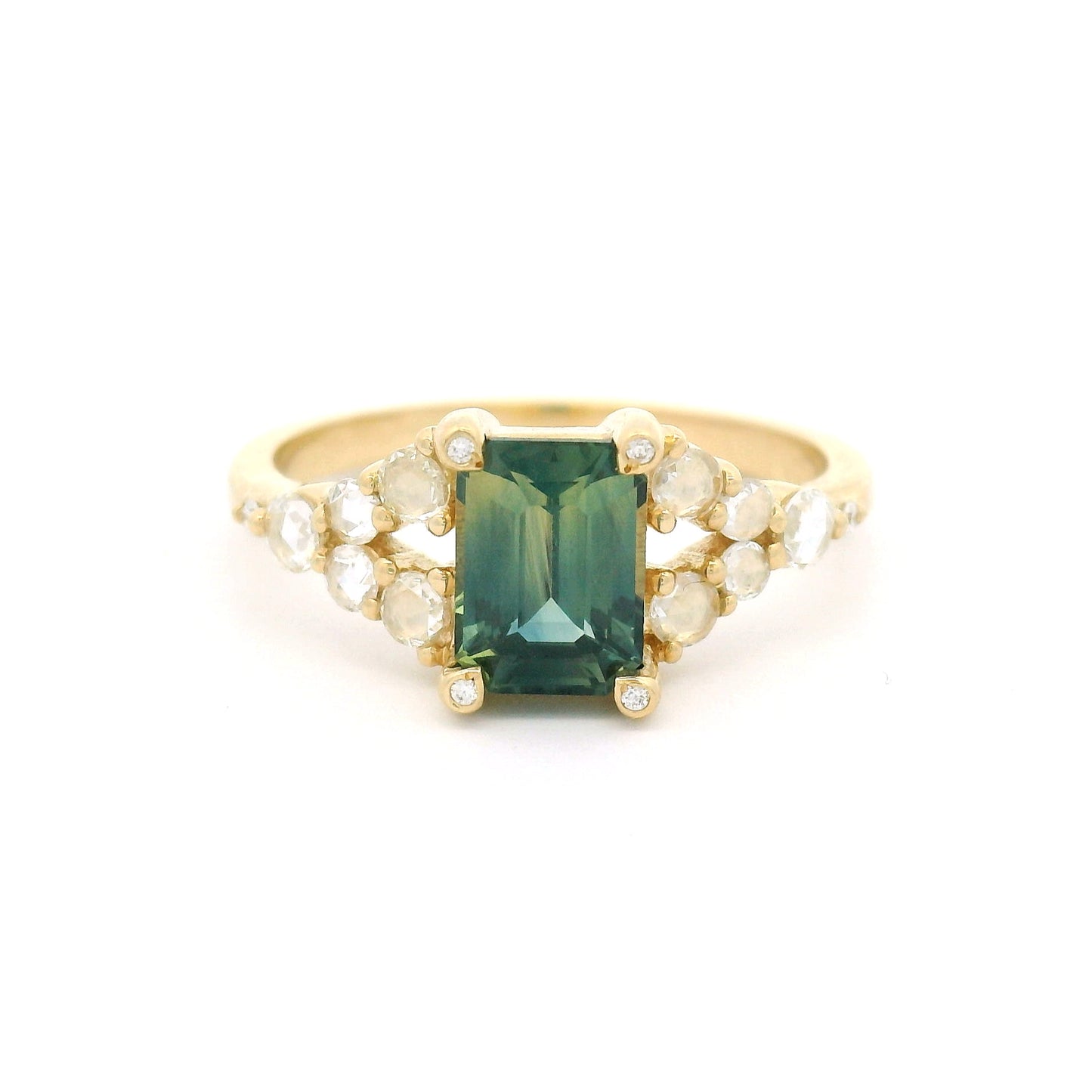 14K yellow gold split shank engagement ring featuring a 1.25ct emerald-cut bluish-green bi-colour sapphire with rose-cut and round brilliant-cut diamond accents.