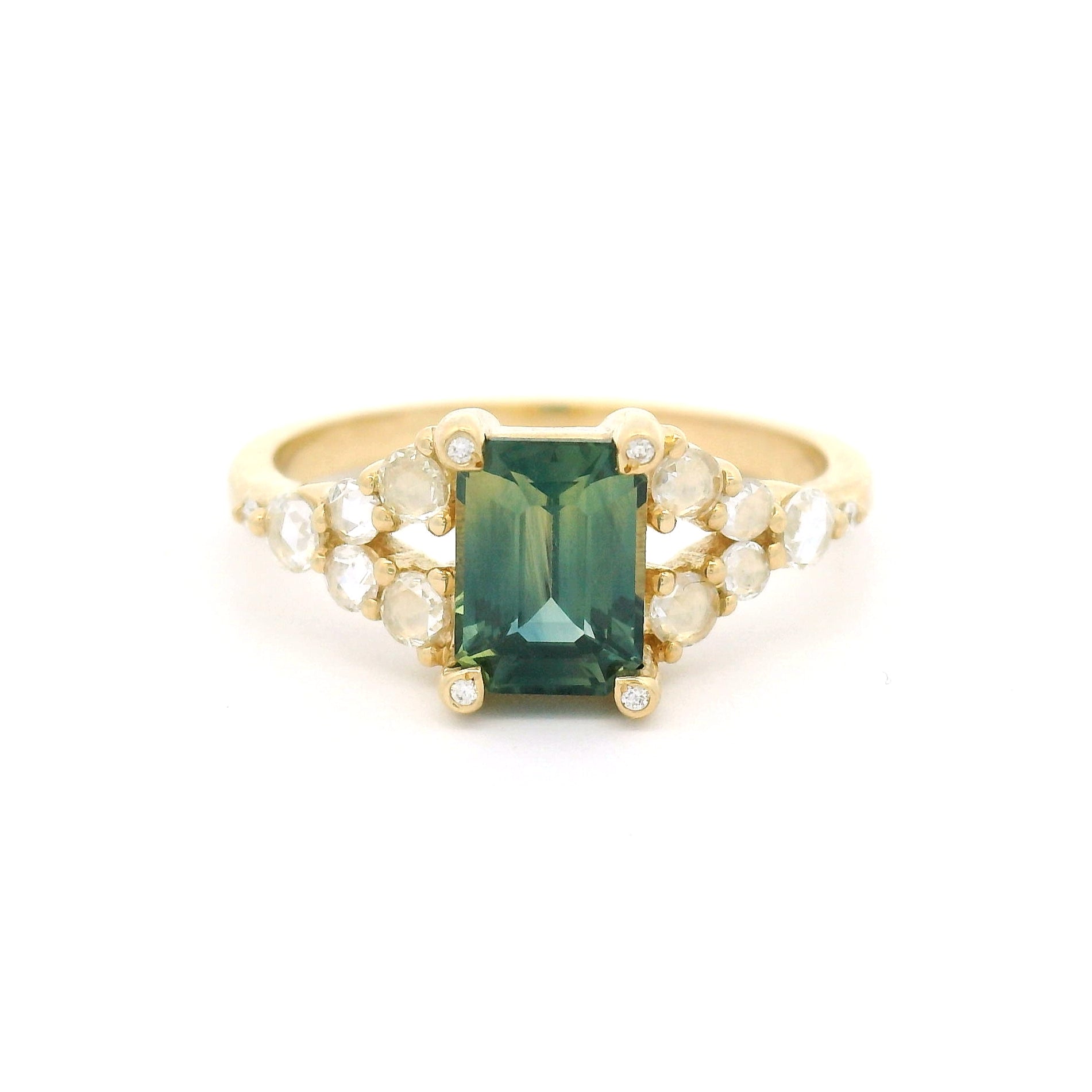 14K yellow gold split shank engagement ring featuring a 1.25ct emerald-cut bluish-green bi-colour sapphire with rose-cut and round brilliant-cut diamond accents.