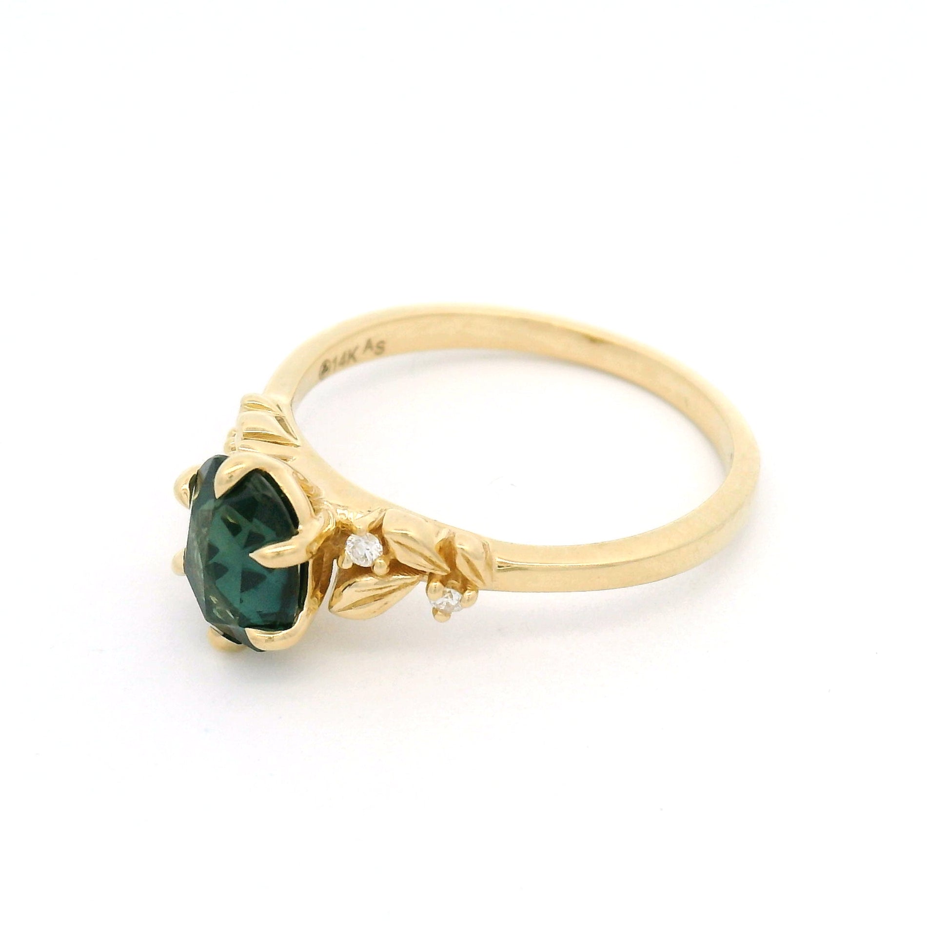 14K yellow gold engagement ring featuring a 1.1ct oval rose-cut green sapphire with diamond accents and sculpted leaf detailing on a delicate band.