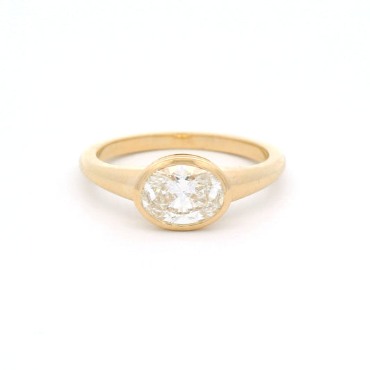 14K yellow gold east-west oval bezel solitaire ring with a 1.0ct lab-grown diamond, tapering shoulders and low-profile signet-inspired design.