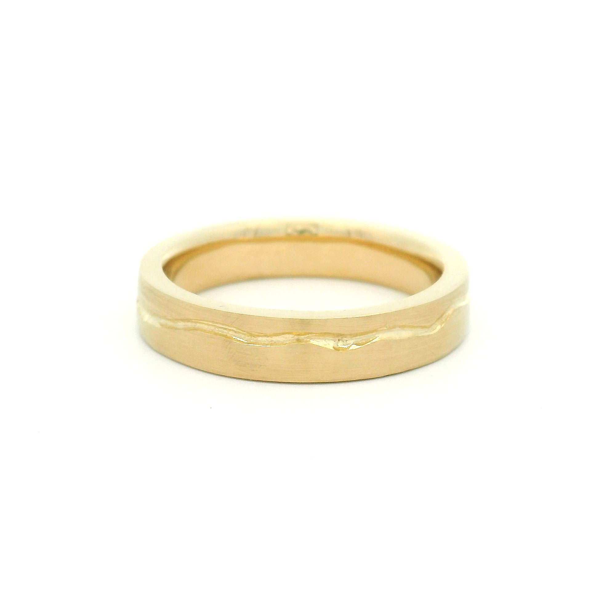 10K yellow gold 4mm wedding band with a soft flat profile, satin finish, comfort-fit interior, and delicate wandering cut path wrapping the band.