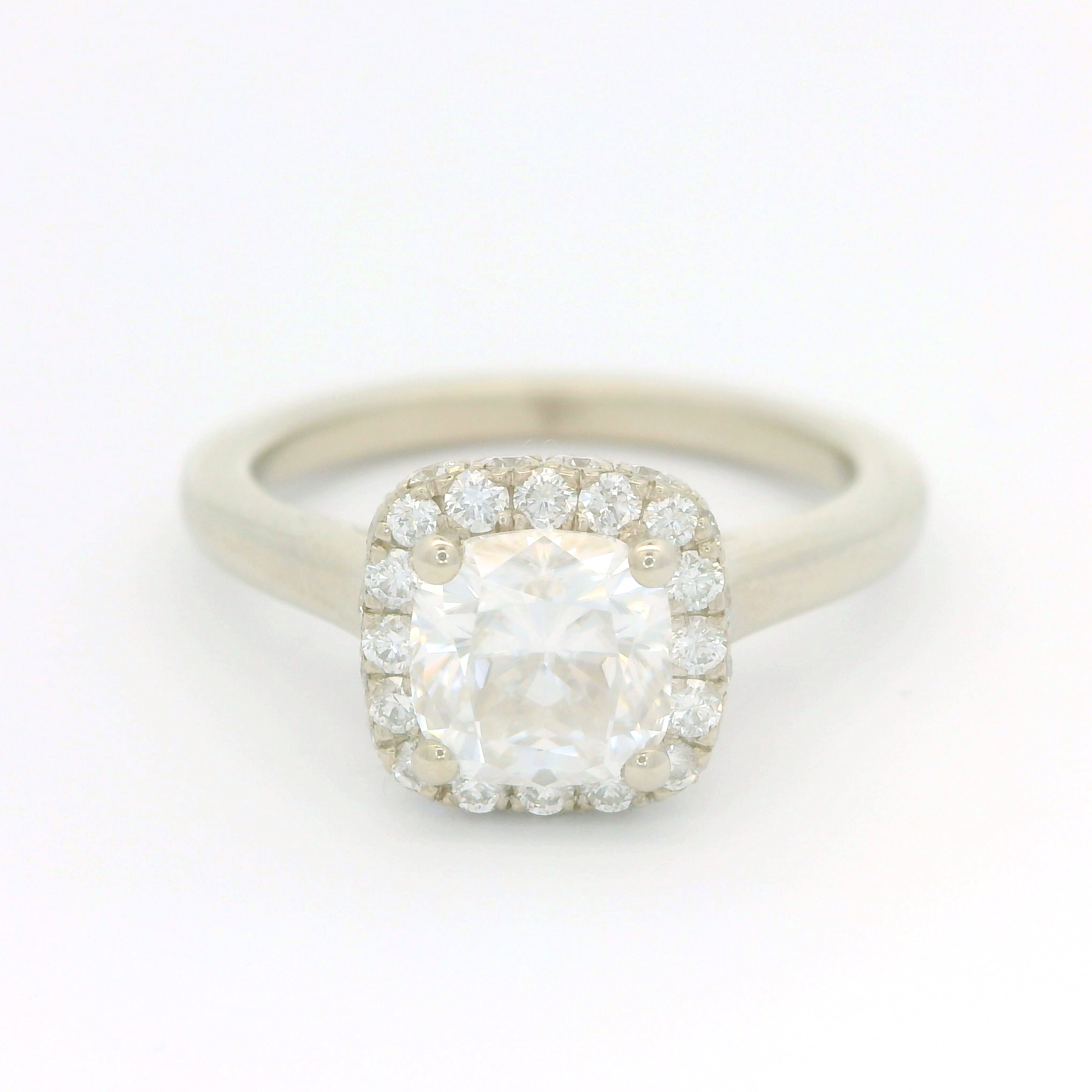 14k white ring set with a 1.1ct moissanite and a accent double sided diamond halo.