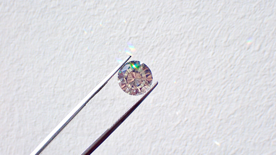 Pair of Tweezers Holding Up a Type of Diamond